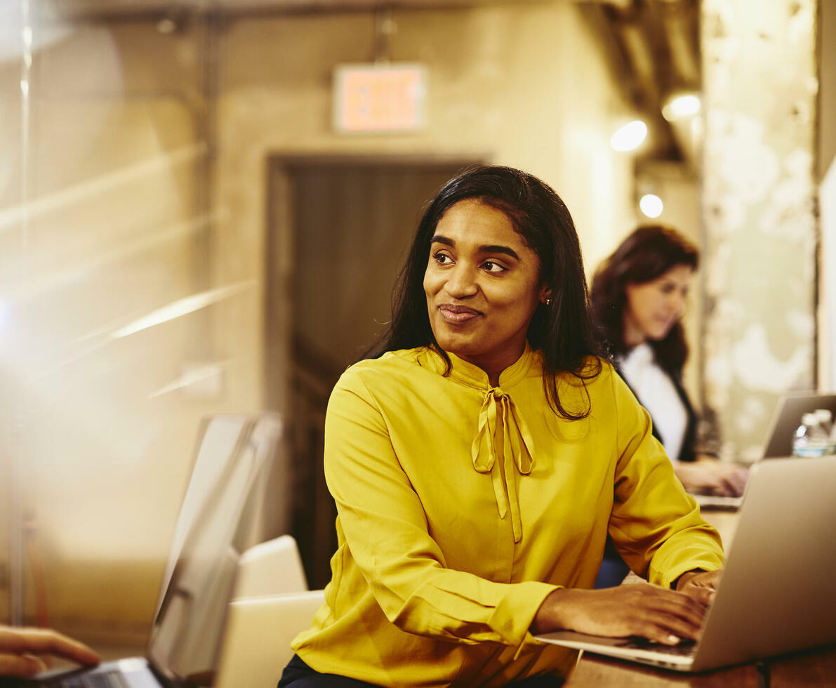 Two smiling female working on their laptop.
Two smiling female working on their laptop.