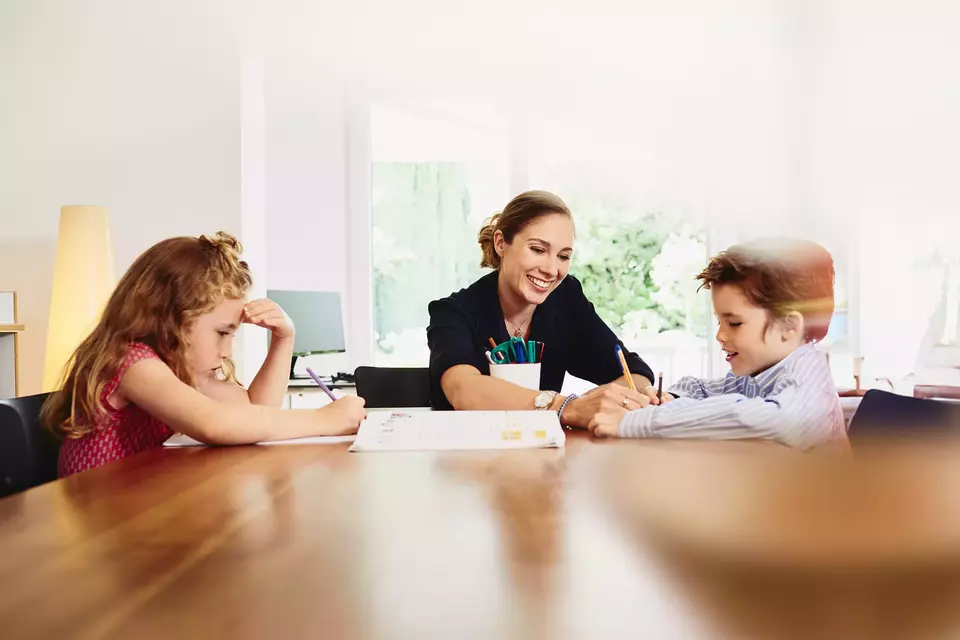 smiling female helping two children